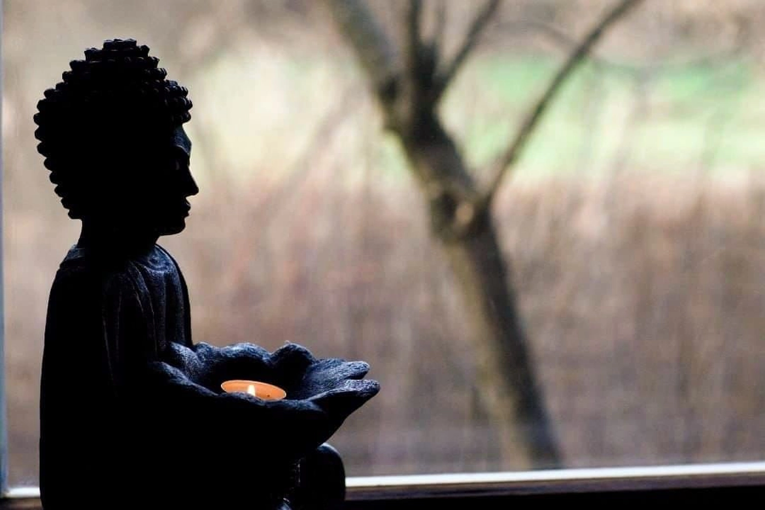 herzoklang, Statue eines Buddha, der eine Kerze trägt